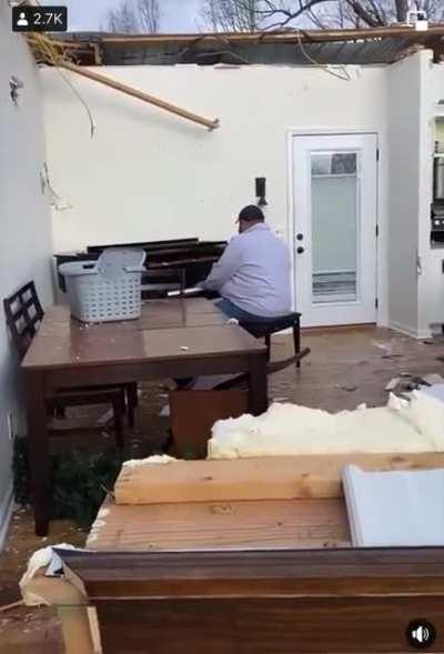 Kentucky man whose home was destroyed by the tornados sits in the remains of his living room and plays a Hymn on his piano.