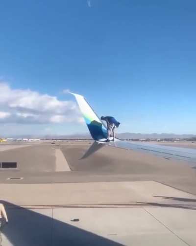 Man climbs onto the wing of a plane waiting for take-off after breaking into a Las Vegas airport runway area
