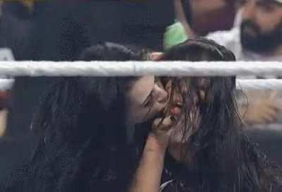 Paige kissing AJ Lee on the cheek