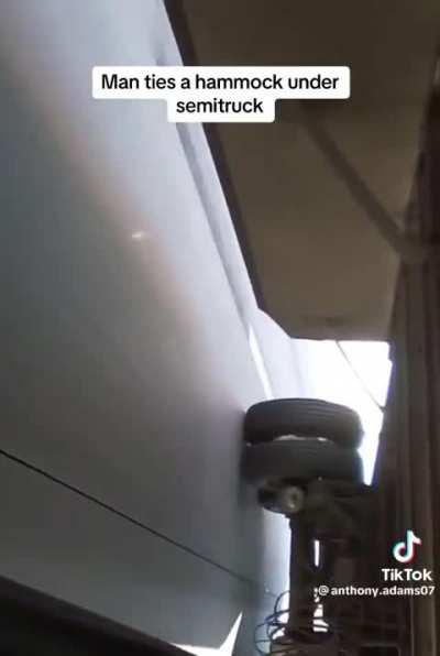 Hammock under a semi truck.