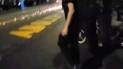 Rioter blocks a truck's path with a motorcycle. Truck driver thinks otherwise.