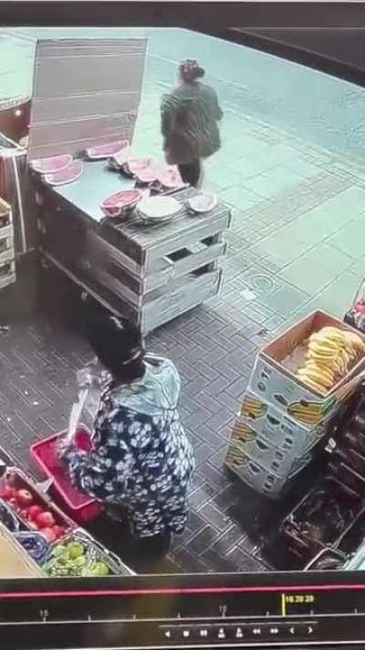 Woman randomly takes a bite out of a watermelon slice on display to sell