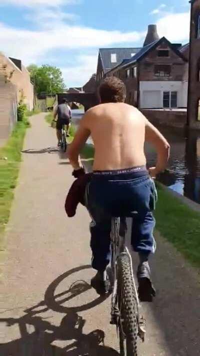 Guy pushes random cyclist into river