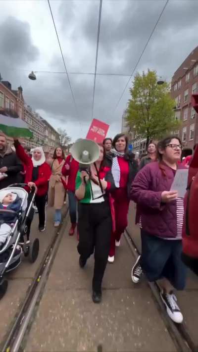 Dutch MP Esther Ouwehand joins the Amsterdam demonstration, where more than 250,000 people rallied in support of Palestine, wearing a shirt in the colors of the Palestinian flag and chanting in solidarity with the Palestinian people.