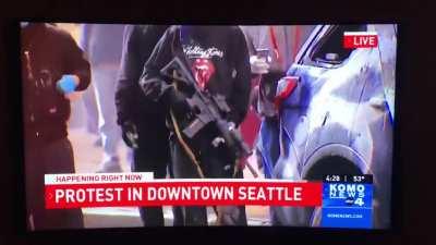 A man disarms a rioter that took a rifle out of a police cruiser in Seattle