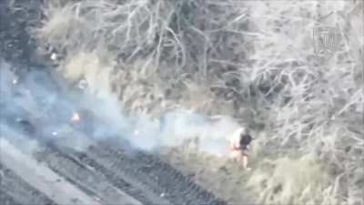 A burning Russian tank crew member of a Russian T-90M jumps out after the tank is hit by an FPV drone.