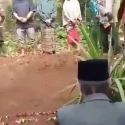 its a funeral, he's about to pee on a new grave