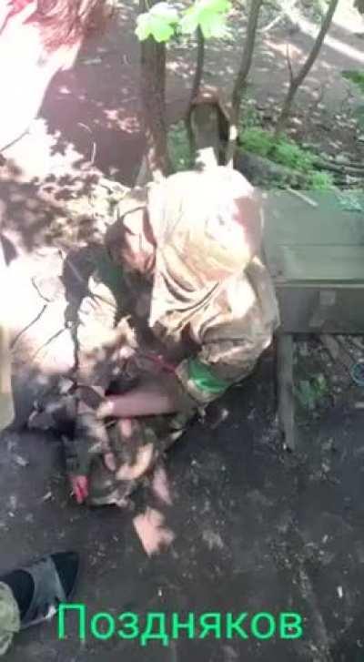 Captured Ukrainian soldier being interrogated with an axe