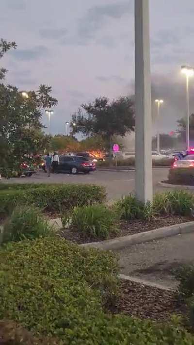 Car on fire in parking lot.