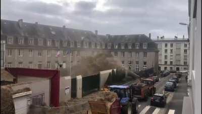 French farmers are spraying manure on government buildings. They are protesting about taxes and regulations that are squeezing them out of business