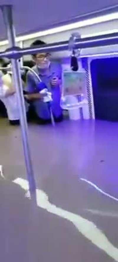 Subway passengers trapped waist-high in floodwaters as Chinese river banks burst