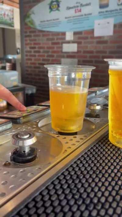 Cup that fills from the bottom to reduce foam