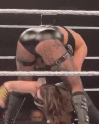 Rhea bent over pulling Nikki Cross by her hair