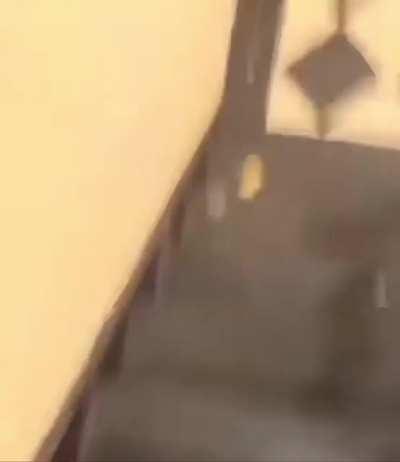 Guys walks over a man for sleeping in the building stairway