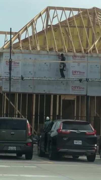 A construction worker consistently throws blocks of wood to the perfect height for almost effortless catching.