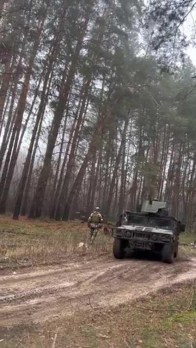 Ukrainian Special Forces in humvees passing by a demining group in Donbas.