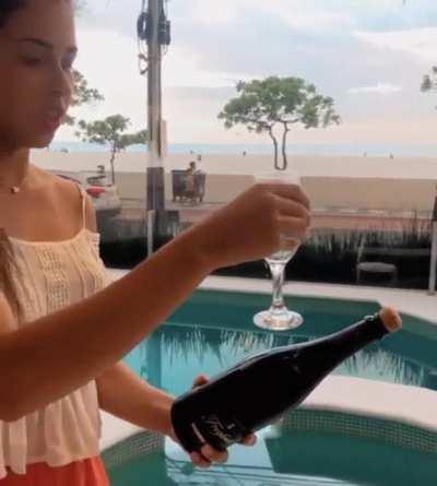 This woman popping a cork with a glass trick.