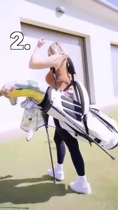 picking up her golf bag