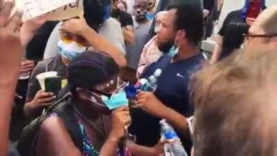 Brave Priest defending St. Louis Statue from BLM