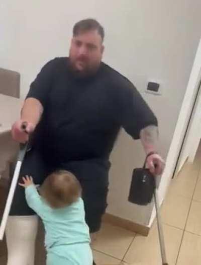 Little girl helping her dad who recently suffered an injury