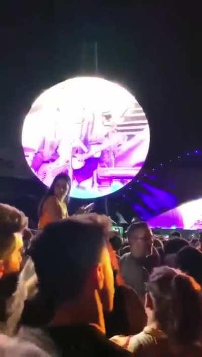 Karen gets hit with plastic bottle after piggyback during Coldplay concert and obstructing the concert view for the people behind her