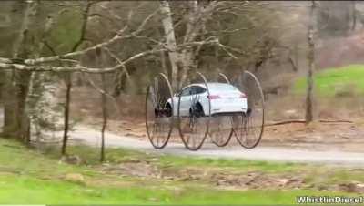 Man puts 10ft buggy wheels on a Tesla and drives it upside down
