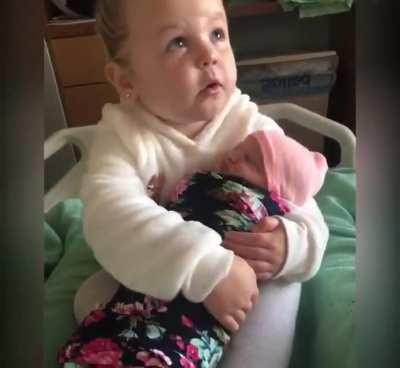 3-year old girl meets her baby sister for the first time.