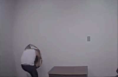 Man escapes the interrogation room by kicking a whole in the wall