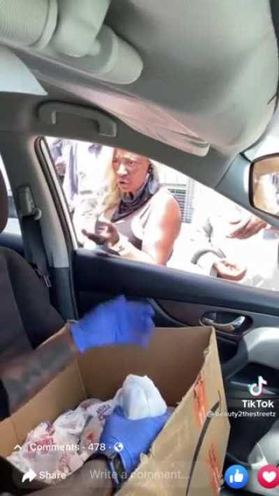 Lady throws food back at woman feeding her.