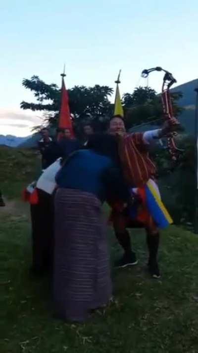 Apparently, It's a tradition in Bhutan to see if a man can shoot straight when his manhood is being touched.