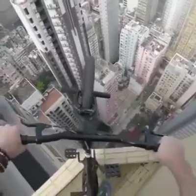 Man rides his bike on skyscraper.