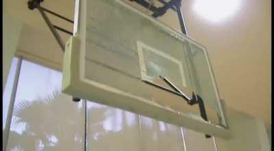 A young Shaquille O’Neal shattering the backboard on a dunk.