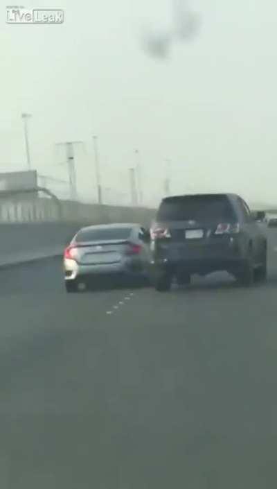 Guy tries fighting with car on highway, falls out of car.