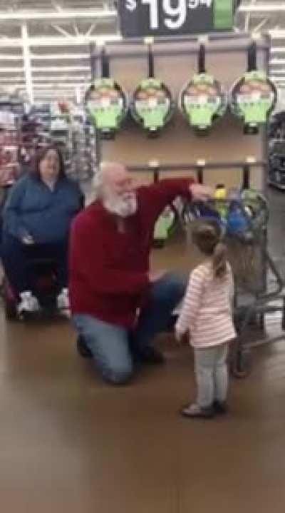 Little girl thinks stranger is Santa, he obliges.