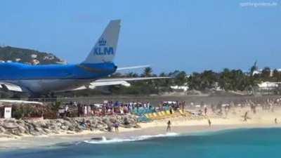 Standing behind a jumbo on a runway