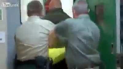 Inmate acting a fool is escorted back to his cell.