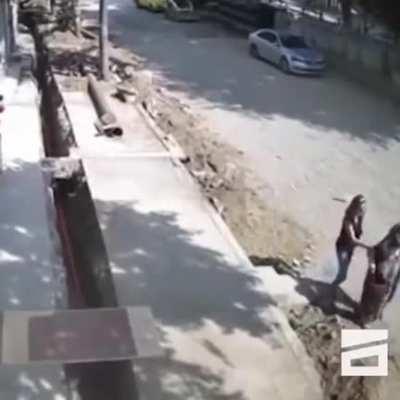 A young man prevents an older woman from falling