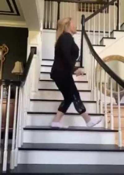 An old woman trying to shuffle dance upstairs in socks