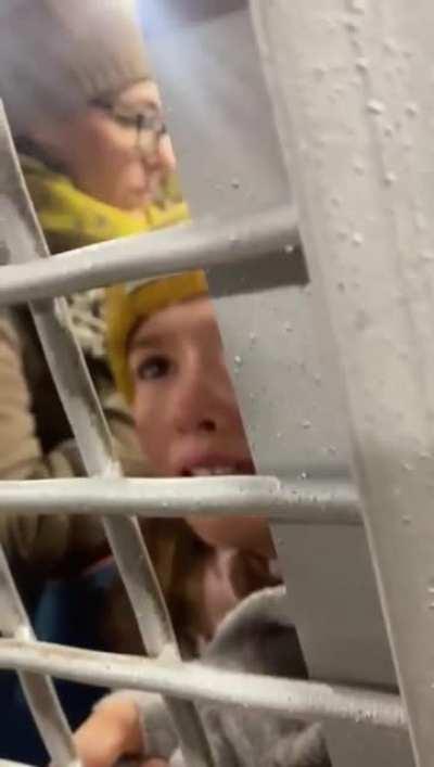Russian child detained in police vehicle with her mother for protesting the war.