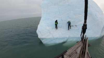 Idiots climb an iceberg which flips over.