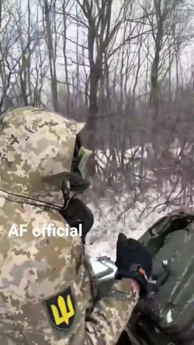 Ukrainian tanker on the move passes another tank concealed in the treeline.