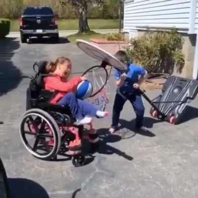 brother is helping his sister to make the shot!