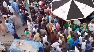 Two young women walk the streets of Pakistan without full religious covering and are surrounded by a large group of men