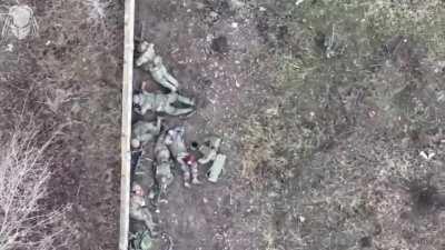 Ukrainian drone drops grenade on 6 Russian troops taking cover next to a wall, grenade shrapnel clearly visible