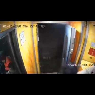 standing near a door on a moving train at night