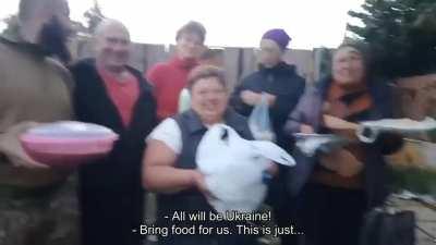 People greething Ukrainian soldiers in liberated village, Kharkiv region