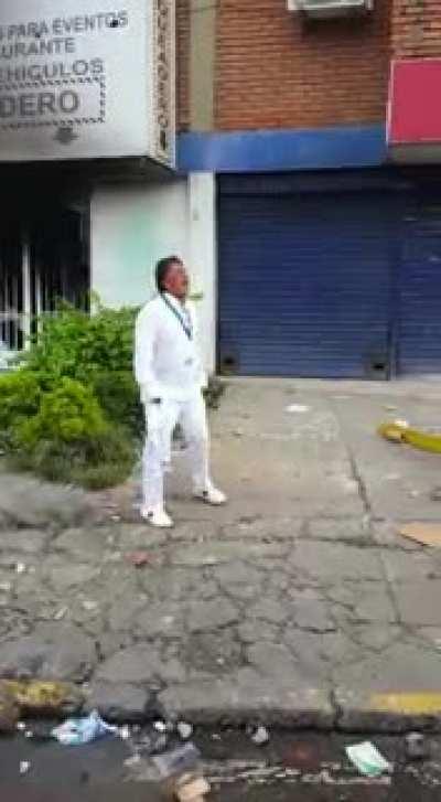 Man crying in front of his hotel after it being burnt yesterday in Colombia's protests