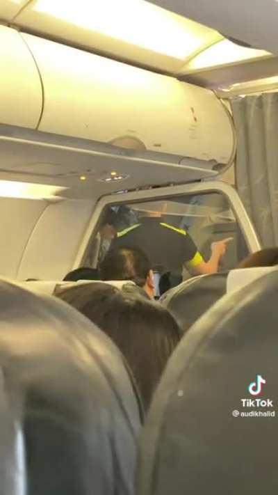 Flight from Bali to Singapore made to circle and hold as passenger refused to buckle up. Family subsequently escorted off plane at Changi Aiport by auxiliary police