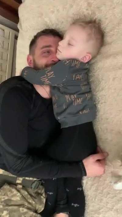 Ukrainian father held close by his son before he has to leave his family again
