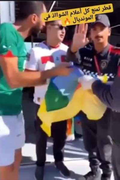 Qatari police stopping someone from entering an Amazigh flag thinking it was an lgbtq flag..